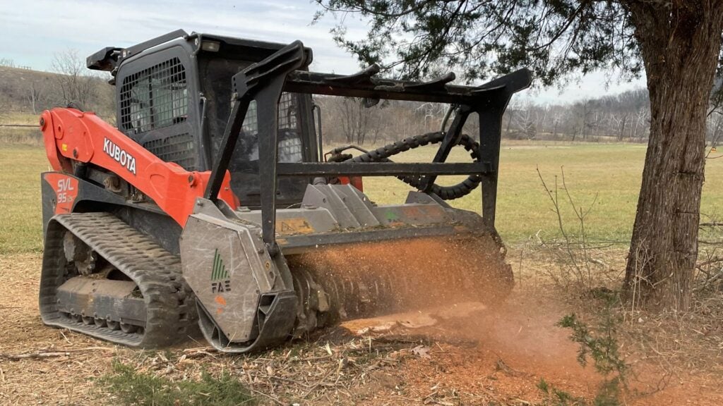A picture of a red vehicle doing forestry mulching.