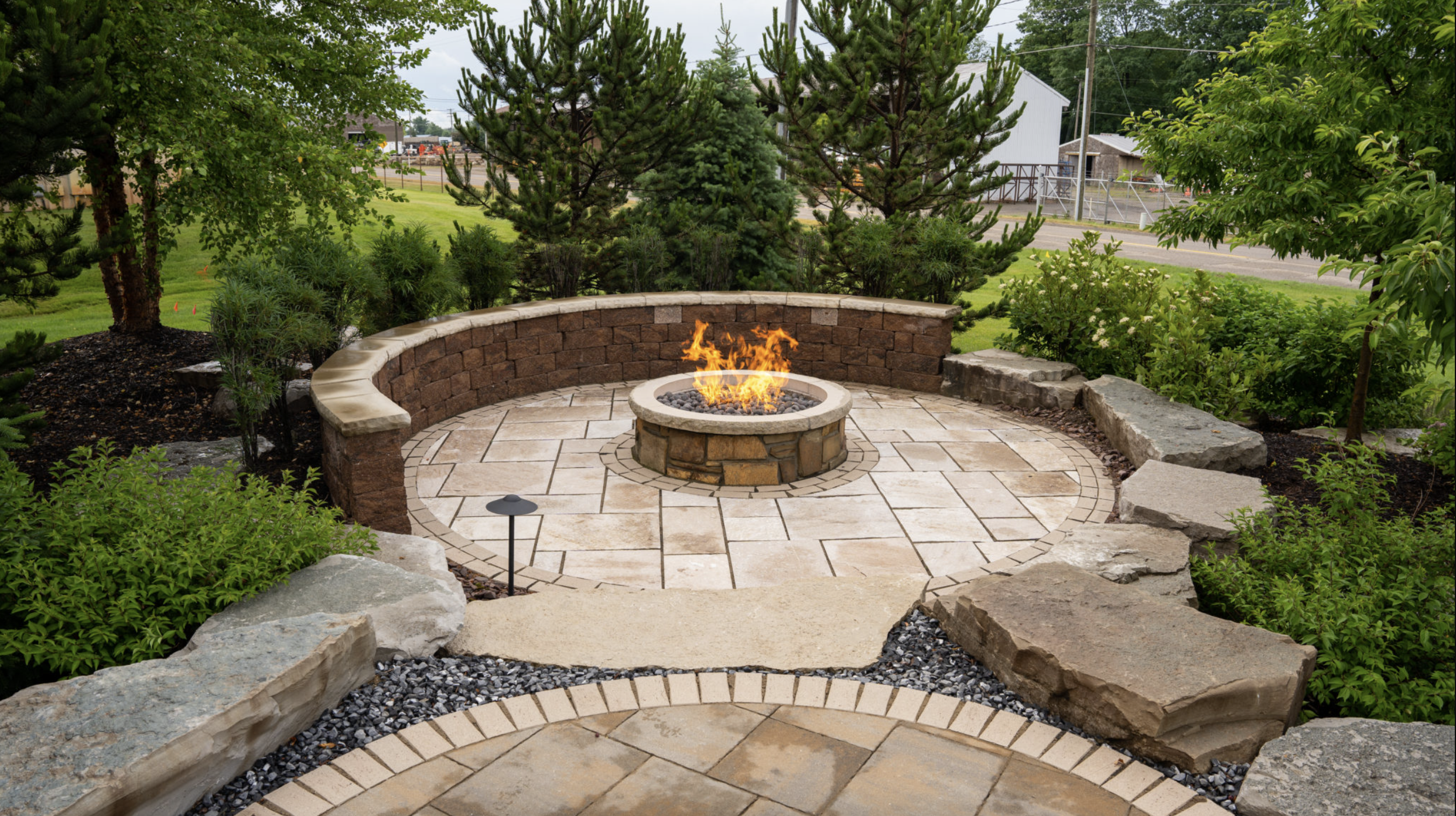 A cozy fire pit surrounded by a stone patio, creating an inviting outdoor gathering space.